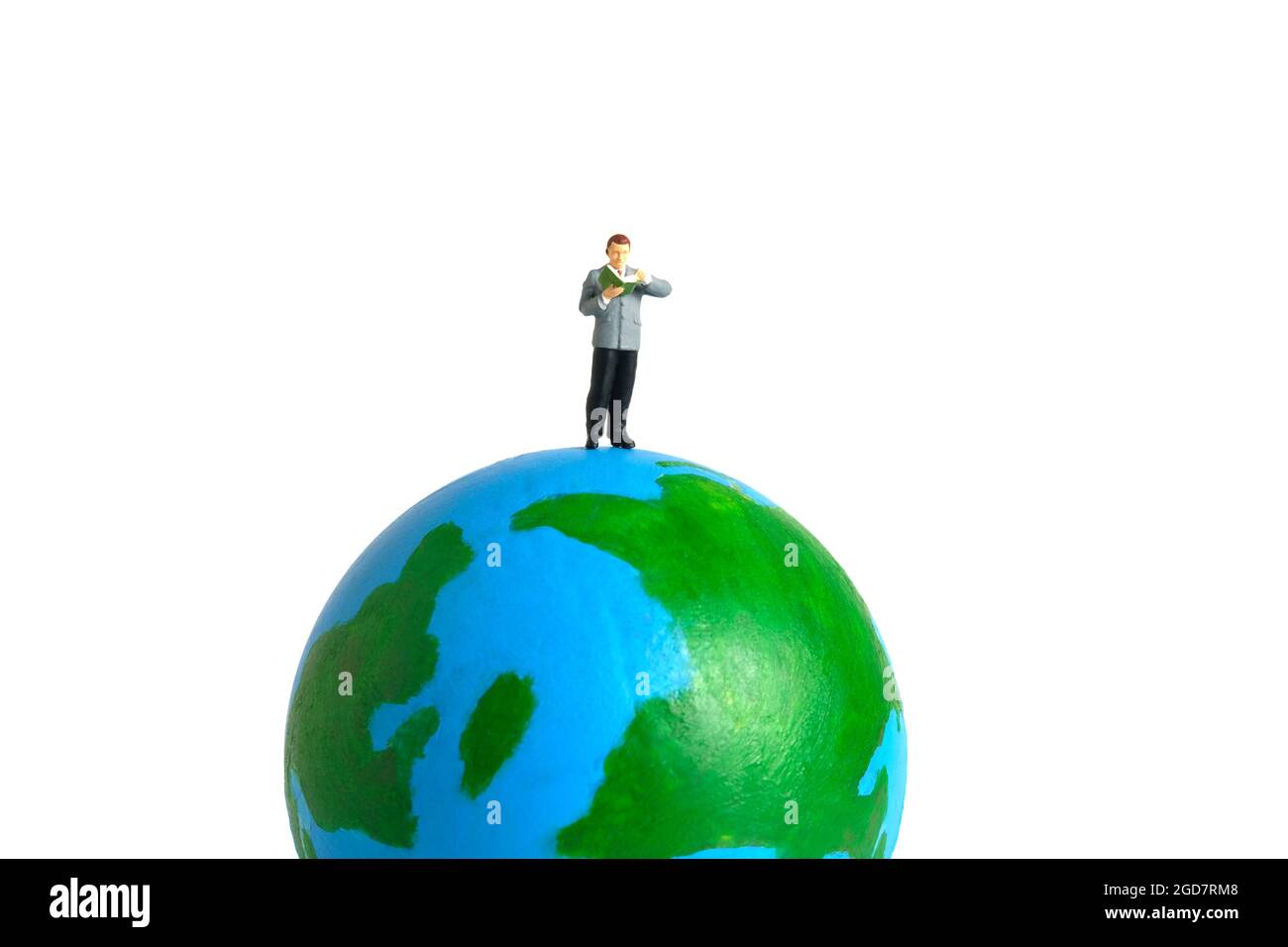 Miniature people toy figure photography. International or National reading day. A men student standing above earth globe while read a book, isolated o Stock Photo