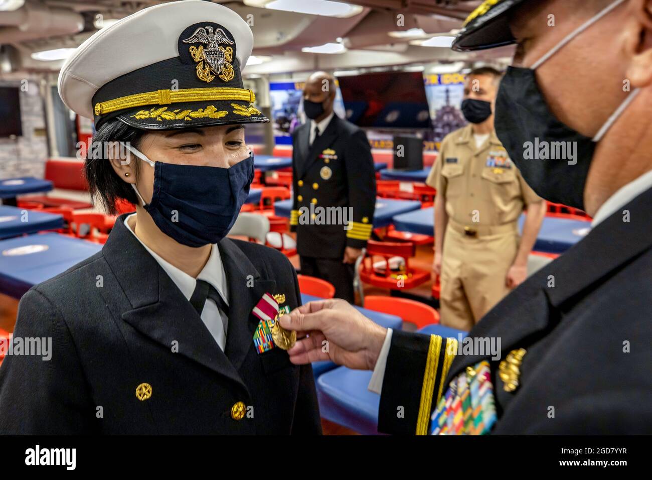 YOKOSUKA, Japan (April 14, 2021) Cmdr. Diane Cua, commanding officer of the Arleigh Burke-class guided-missile destroyer USS Curtis Wilbur (DDG 54), is awarded the Meritorious Sevice Medal by Capt. Chase Sergeant, Commodore of Destroyer Squadron 15, during a change of command ceremony. Cmdr. Anthony Massey shall assume command of Curtis Wilbur, relieving Cua for future naval assignments. Curtis Wilbur is assigned to Task Force 71/Destroyer Squadron (DESRON) 15, the Navy’s largest forward-deployed DESRON and the U.S. 7th Fleet’s principal surface force. (U.S. Navy photo by Mass Communication Sp Stock Photo