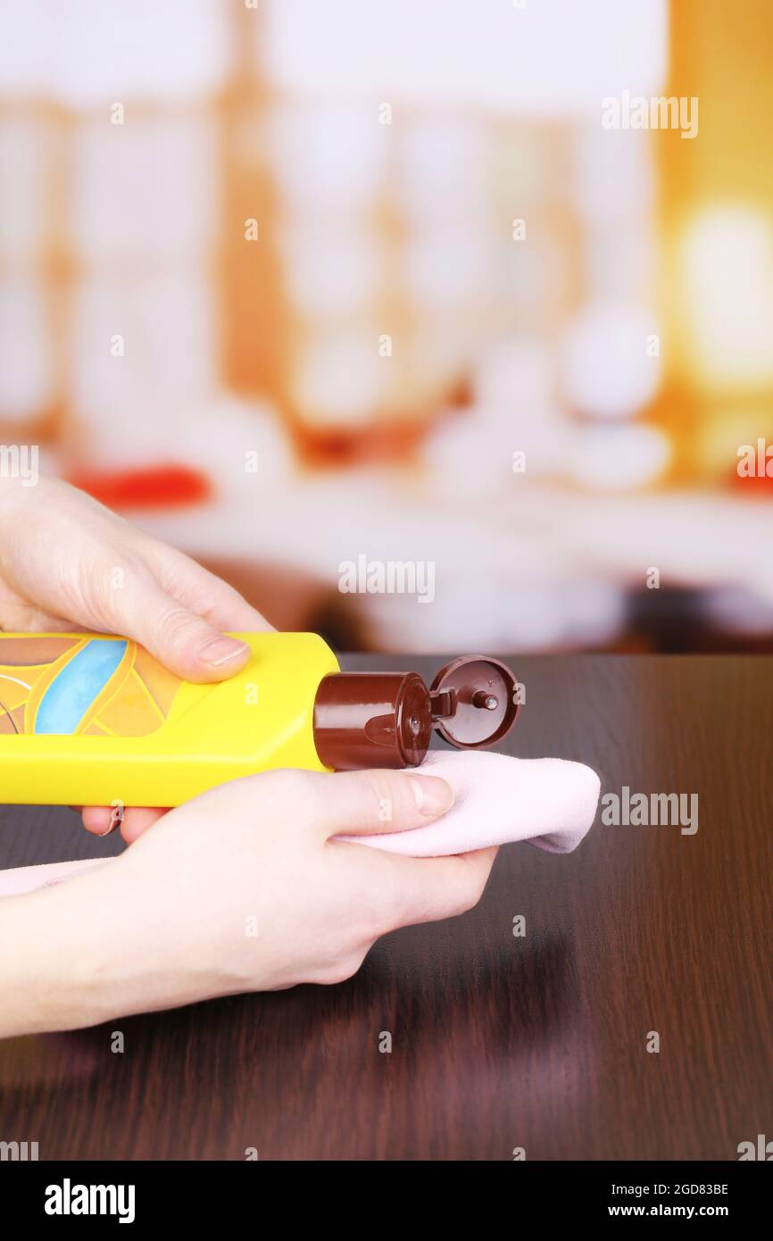 Hand cleaning wooden table with furniture polish Stock Photo Alamy