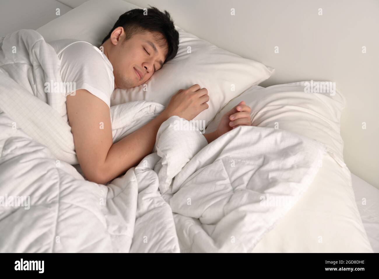 Handsome Young Asian man sleeping in bed Stock Photo