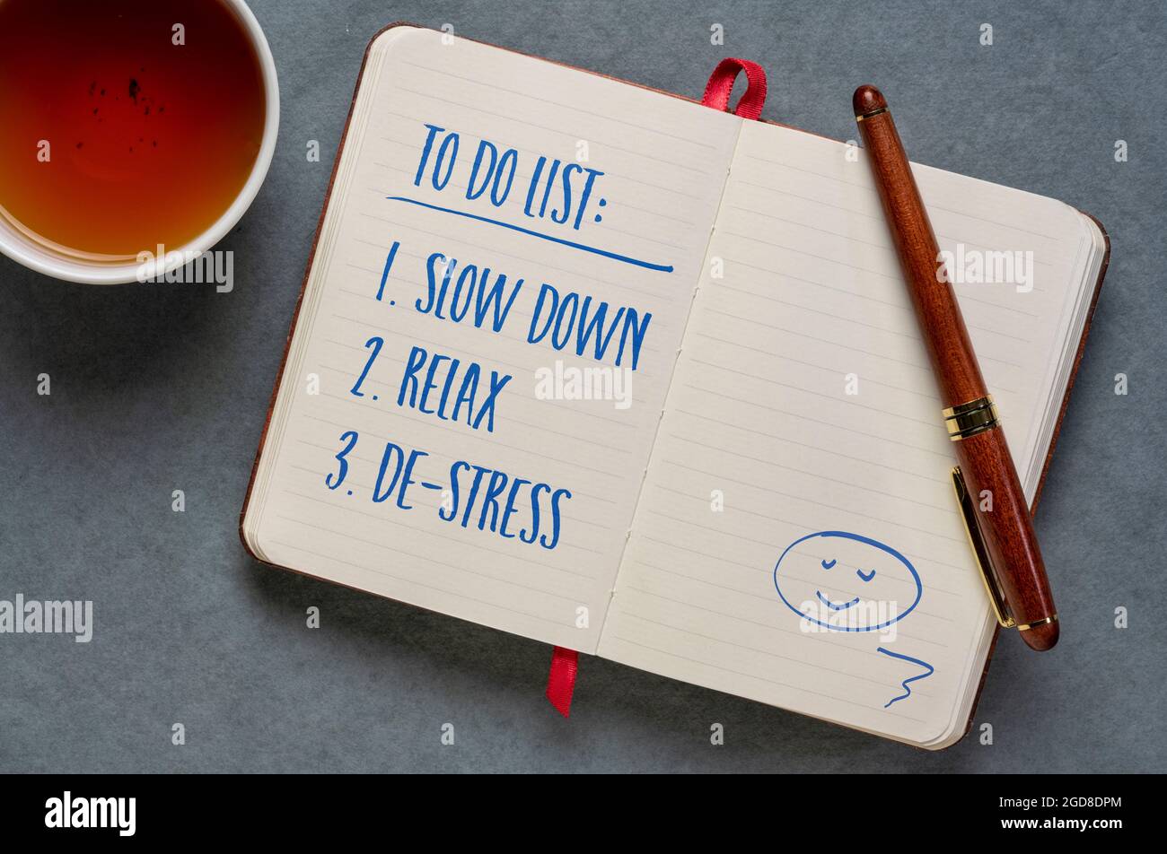 to do list - slow down, relax and de-stress, handwriting in a notebook or journal, journaling, lifestyle and personal development concept Stock Photo