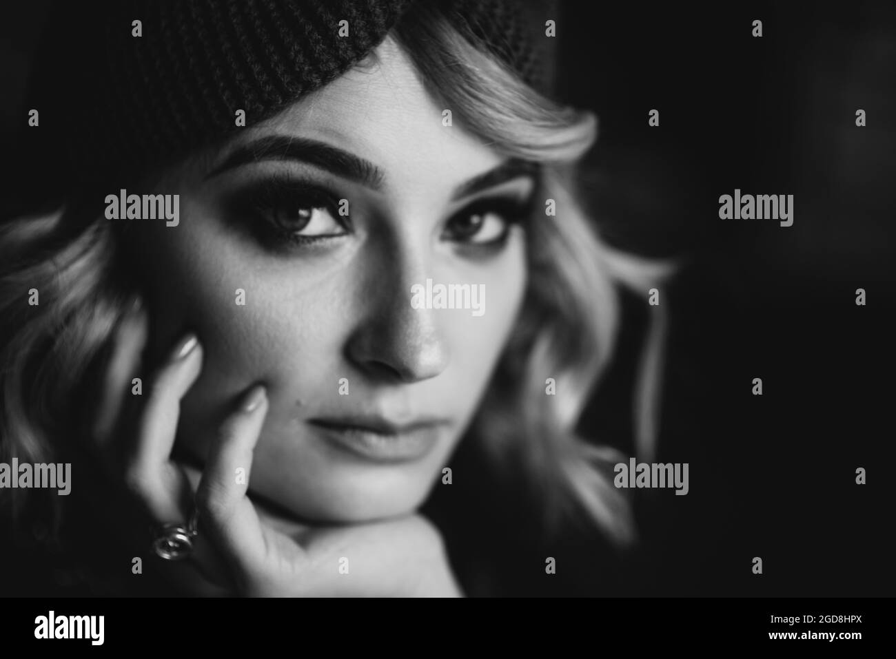 Portrait of a beautiful stylish blonde woman with smoky eye makeup in a knitted headband. Soft selective focus, defocus. Stock Photo