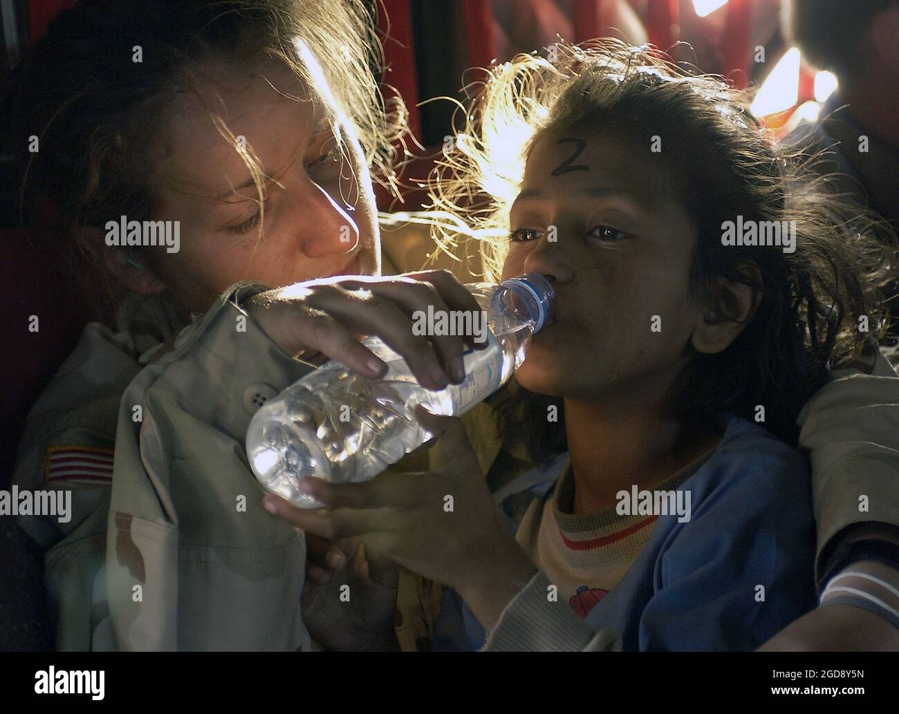 US Army (USA) Sergeant (SGT) Kornelia Rachwal gives a young Pakistani girl a drink of water as they are airlifted from Muzaffarabad to Islamabad, Pakistan, aboard a USA CH-47 Chinook helicopter. The Department of Defense (DoD) Pakistan Earthquake Relief is part of a multinational effort to provide humanitarian assistance and support to Pakistan (PAK) and parts of India (IND) and Afghanistan (AFG) following a devastating earthquake.  (USAF PHOTO BY TSGT MIKE BUYTAS 051019-F-9085B-154) Stock Photo