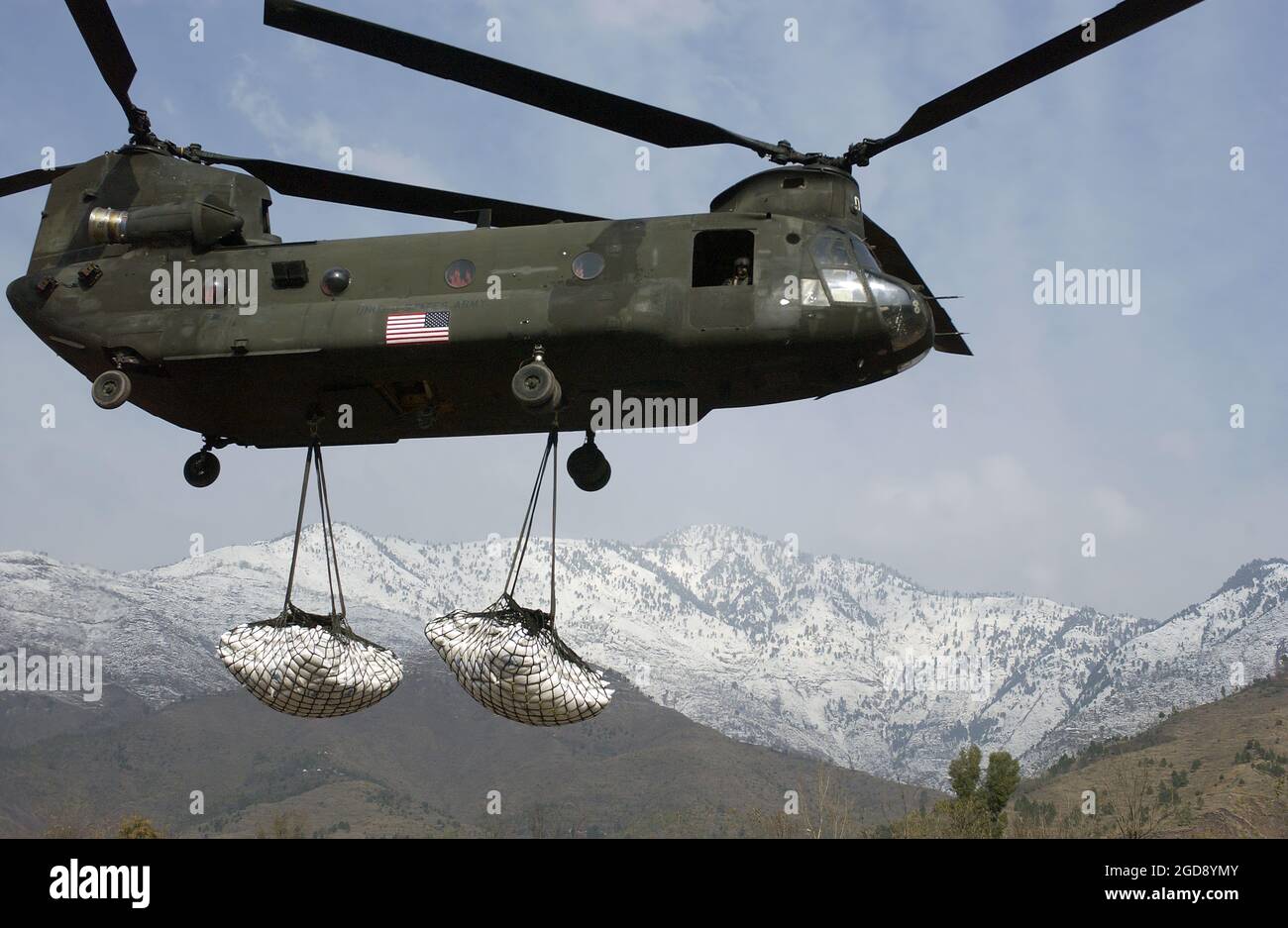 A US Army (USA) CH-47 Chinook cargo helicopter carries two external loads of humanitarian relief supplies (part of a total 125-tons) to assist those trapped by several severe snowstorms in the area around Muzaffarabad, Kashmir Province, Pakistan (PAK), in support of Operation LIFELINE, the Pakistani-led relief operation to aid the victims of a devastating earthquake that hit the area on October 8, 2005.  (USAF PHOTO BY 1LT CHAD LEISENRING 060104-F-3228L-002) Stock Photo