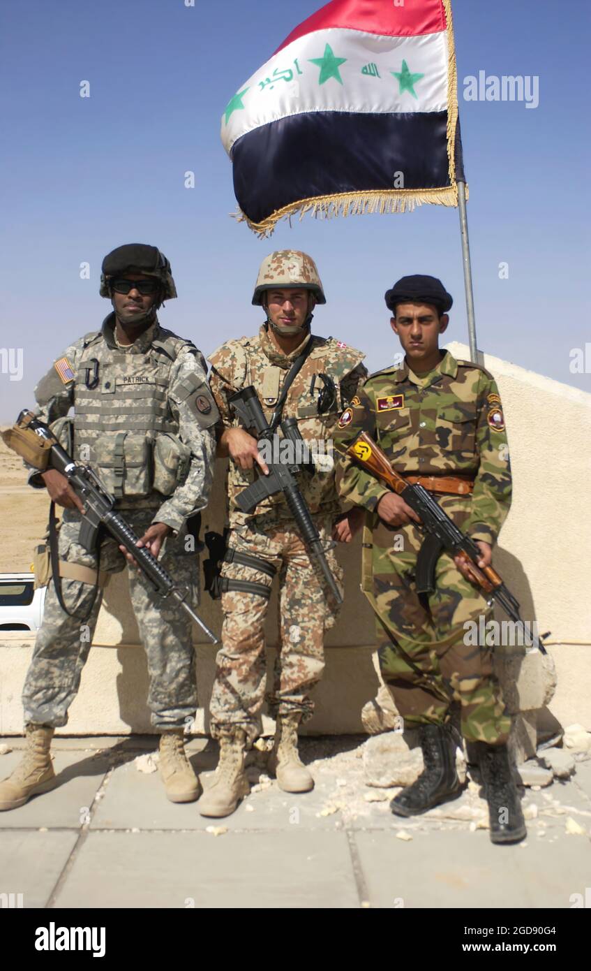 US Army (USA) Lieutenant Colonel (LTC) Bruce Patrick (left), Multi-National Division Central-South (MND-CS), takes a break to pose with Danish Army Captain (CPT) Benny Gottlieb (center) and an Iraqi Border Police (IBP) officer (right) at IBP Fort Karmashiya, Iraq (IRQ), while participating in an official Coalition Force tour of five IBP forts on the Iran-Iraq border conducted during Operation IRAQI FREEDOM.  (USAF PHOTO BY SRA JASON T BAILEY 060325-F-0560B-301) Stock Photo