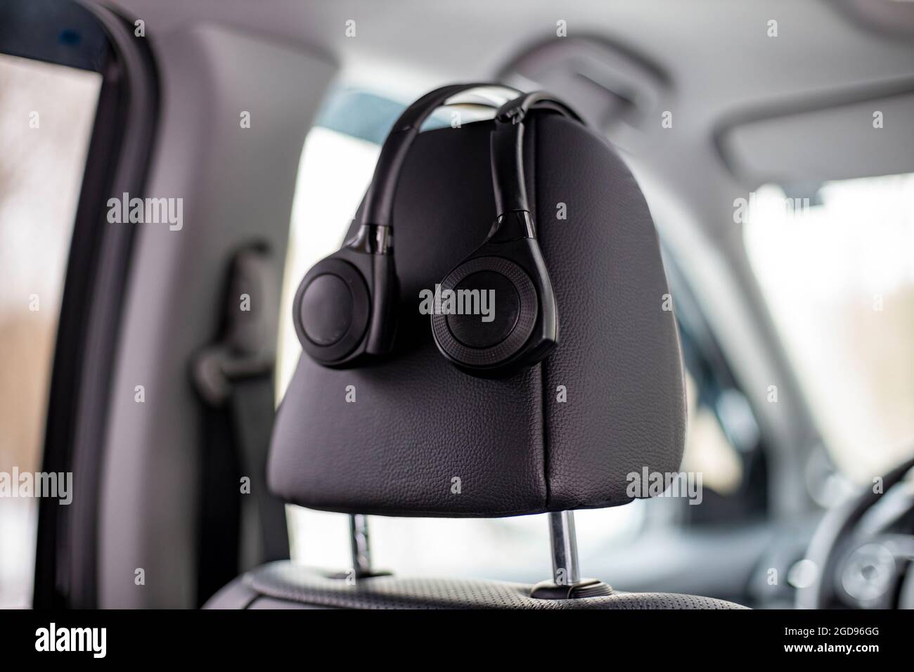 onear headphones hang on the headrest in the car. technology personal