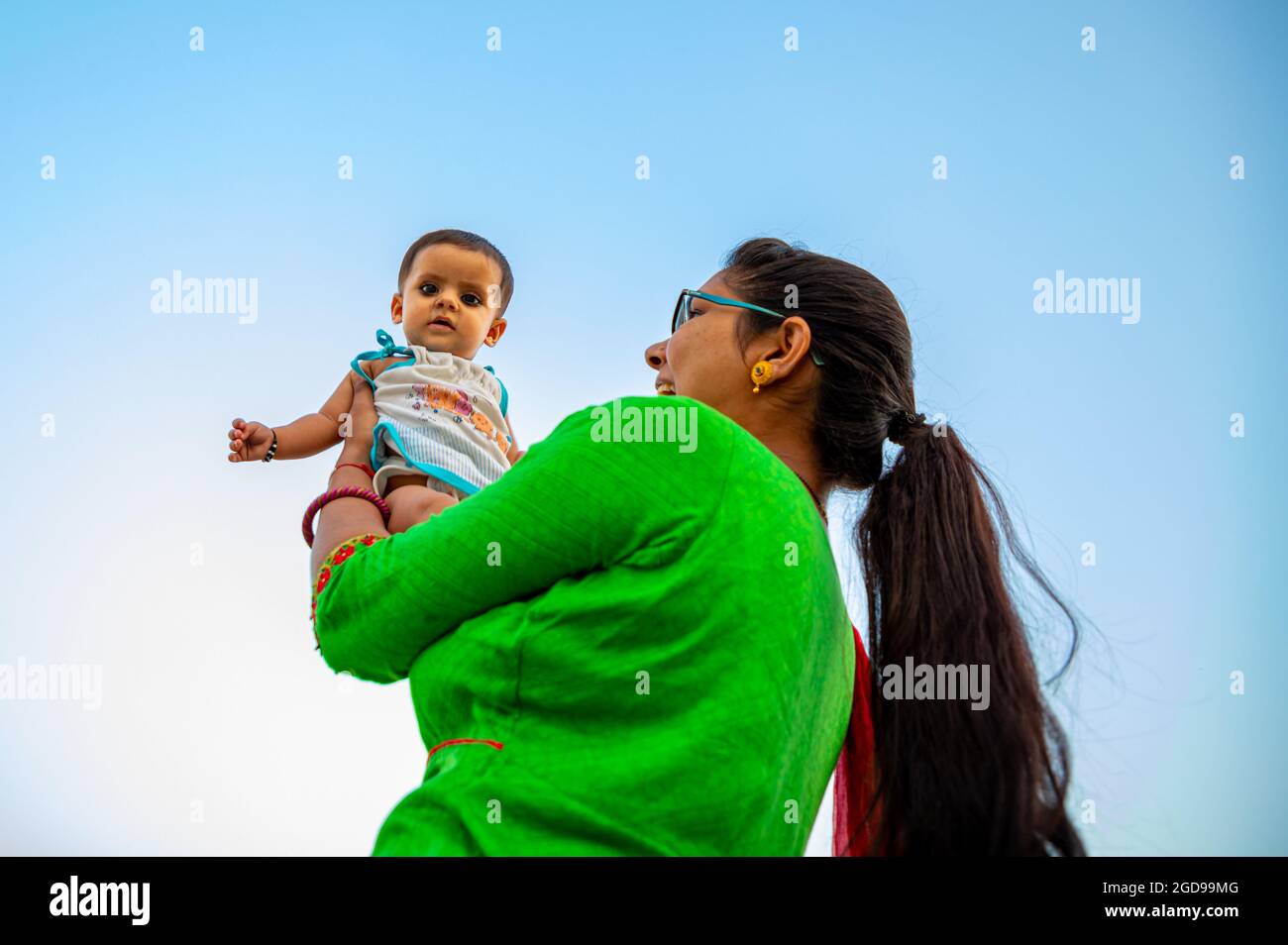 portrait of indian mother lifting and playing with new born baby,positive human emotions, family background. Stock Photo