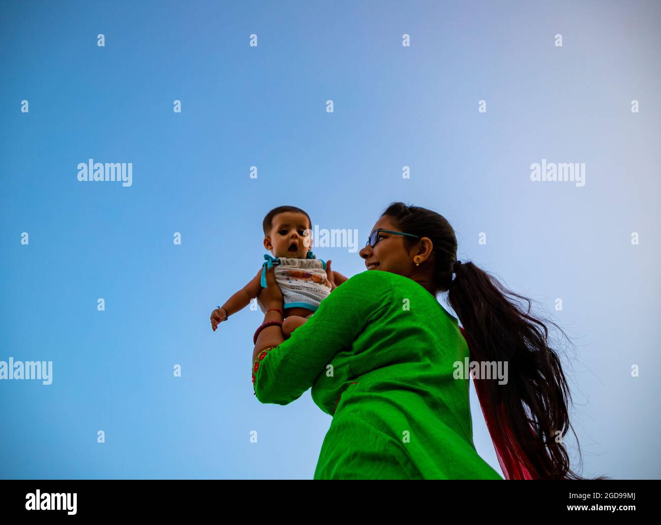 portrait of indian mother lifting and playing with new born baby,positive human emotions, family background. Stock Photo