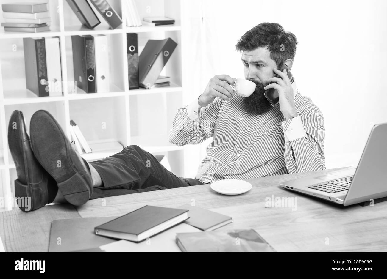 Employee drink cup of tea talking on mobile phone in modern office ...