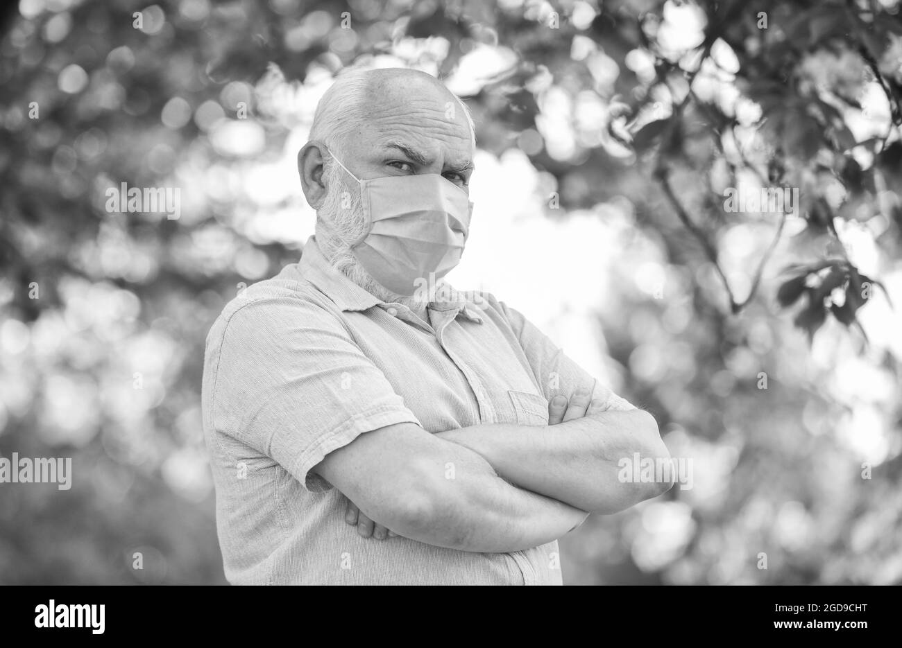 Elderly and other risk groups. Pandemic concept. Limit risk infection spreading. Black and white. Senior man wearing face mask. Older people at highes Stock Photo