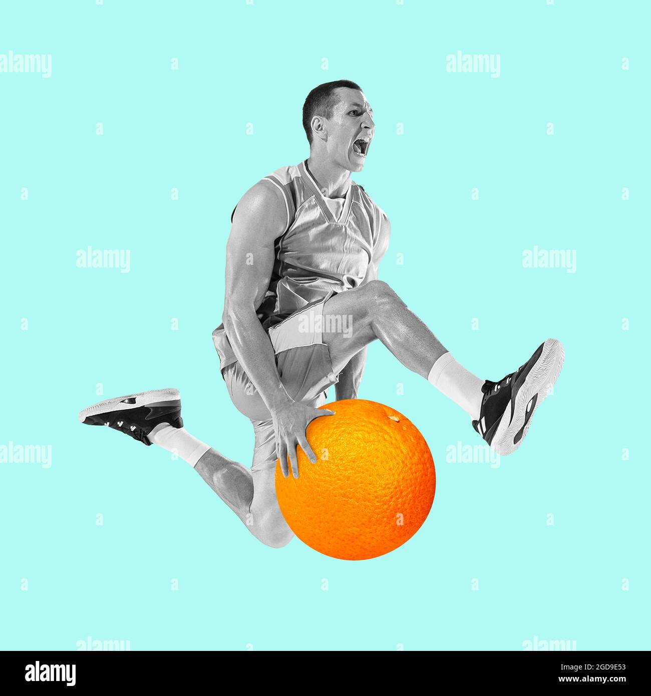 Fit young man jumping with huge orange on blue background. Male