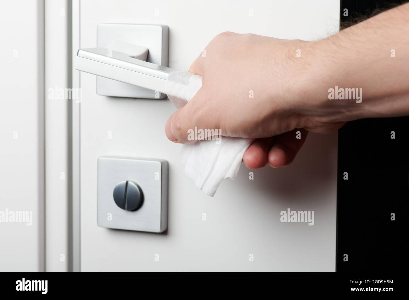 Open door handle with wet wipe on hand close up view Stock Photo
