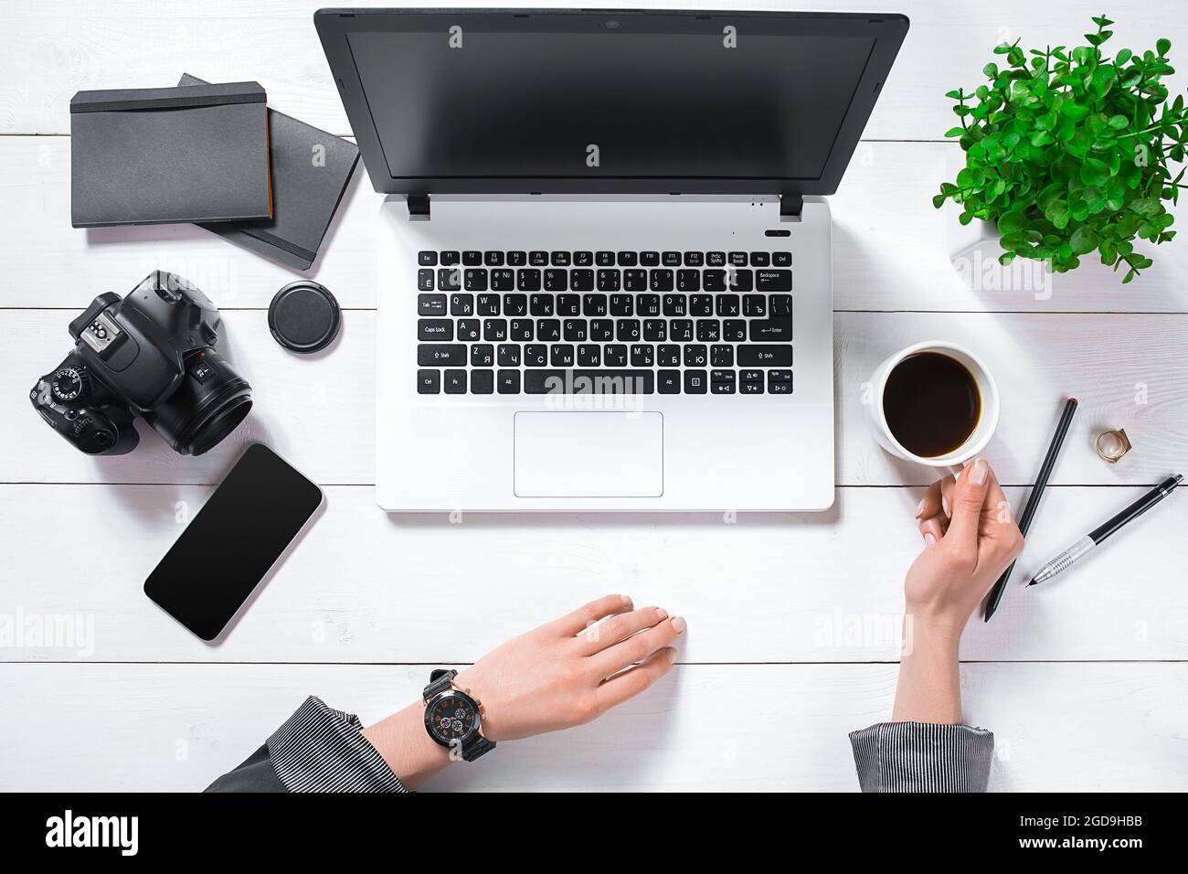 Flat lay, top view office table desk. Workspace with girl's hands, laptop,  green flower in a pot, black diary, coffee mug Stock Photo - Alamy, image size:1300x956
