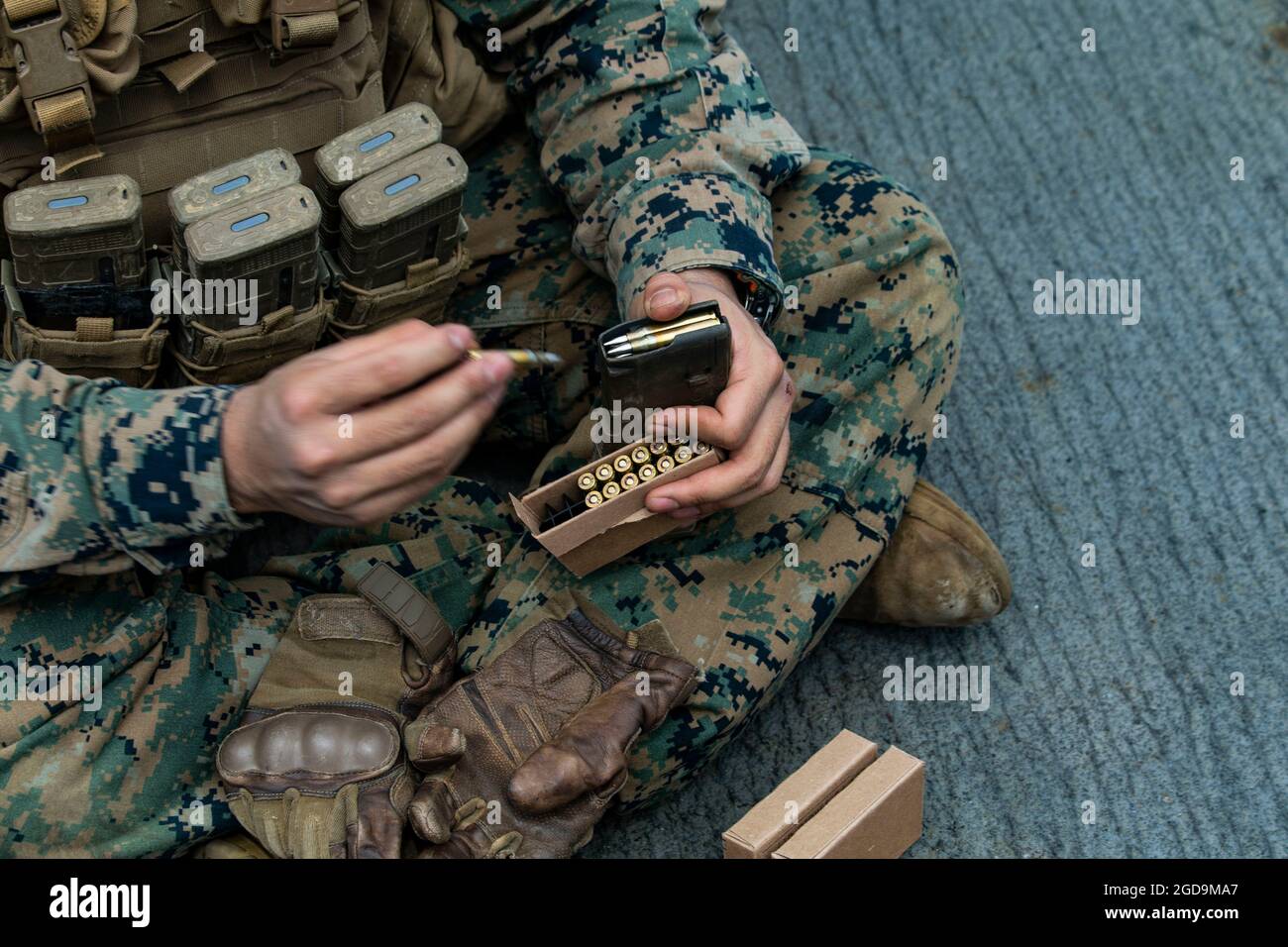 A U.S. Marine with Battalion Landing Team 3/5, 31st Marine Expeditionary Unit (MEU) loads a magazine with live ammunition for a range aboard USS Germantown in the Solomon Sea, August 2, 2021. The range was created to challenge Marines with obstacles to increase tactical proficiency. The 31st MEU is operating aboard ships of the America Expeditionary Strike Group in the 7th fleet area of operations to enhance interoperability with allies and partners and serve as a ready response force to defend peace and stability in the Indo-Pacific region. (U.S. Marine Corps photo by Cpl. Alexandria Nowell) Stock Photo