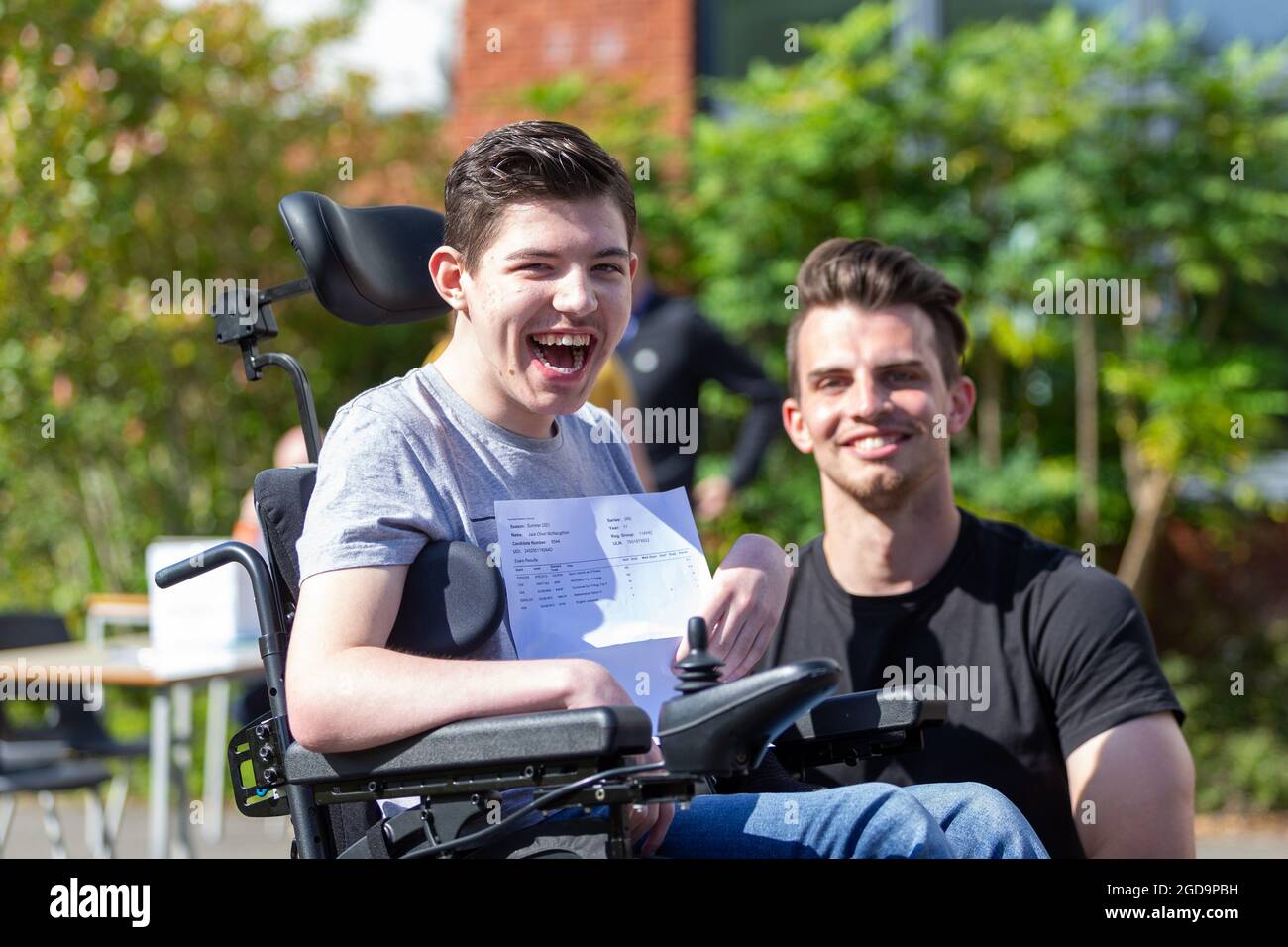 Bromsgrove, Worcs, UK. 12th Aug, 2021. Year 11 student Jack McNaughton, with teaching assistant Ryan, opens his GCSE results at North Bromsgrove High School, Bromsgrove, Worcs. Jack gained 5 passes at GCSE level and is going on to college next year. Credit: Peter Lopeman/Alamy Live News Stock Photo