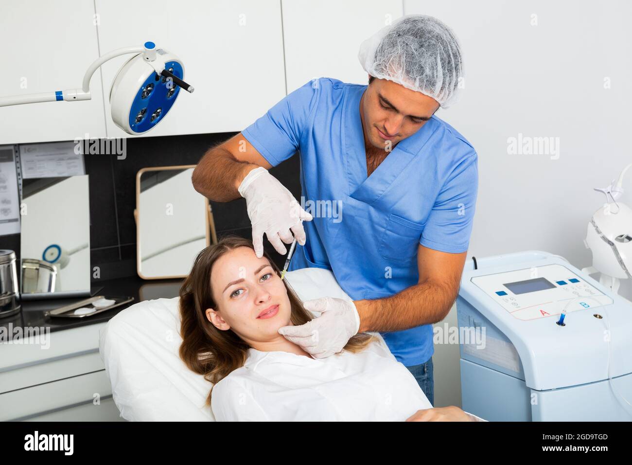 Beautician performing face contouring injections to female patient