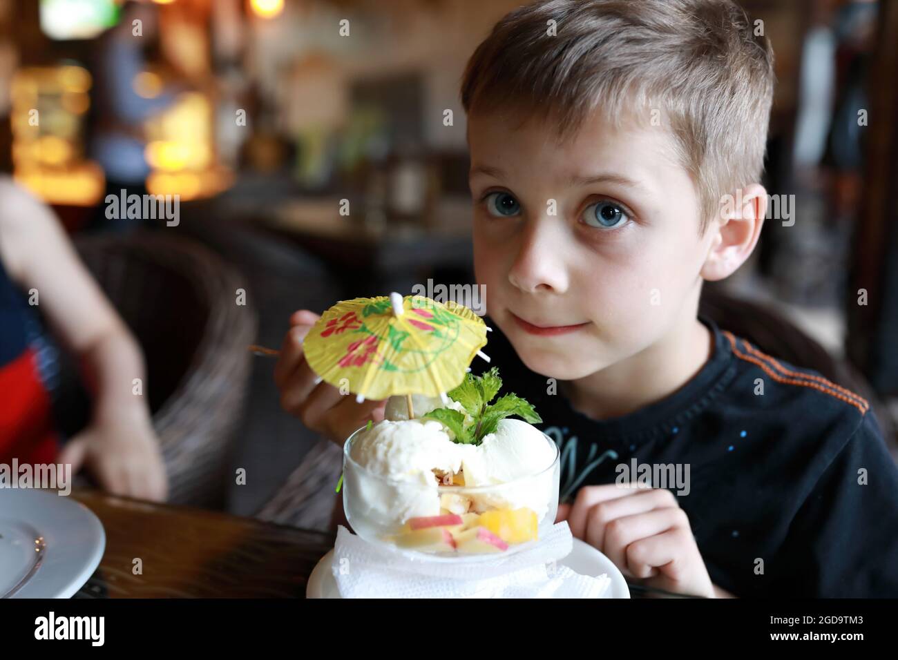 Portrait of child eating ice cream in restaurant Stock Photo