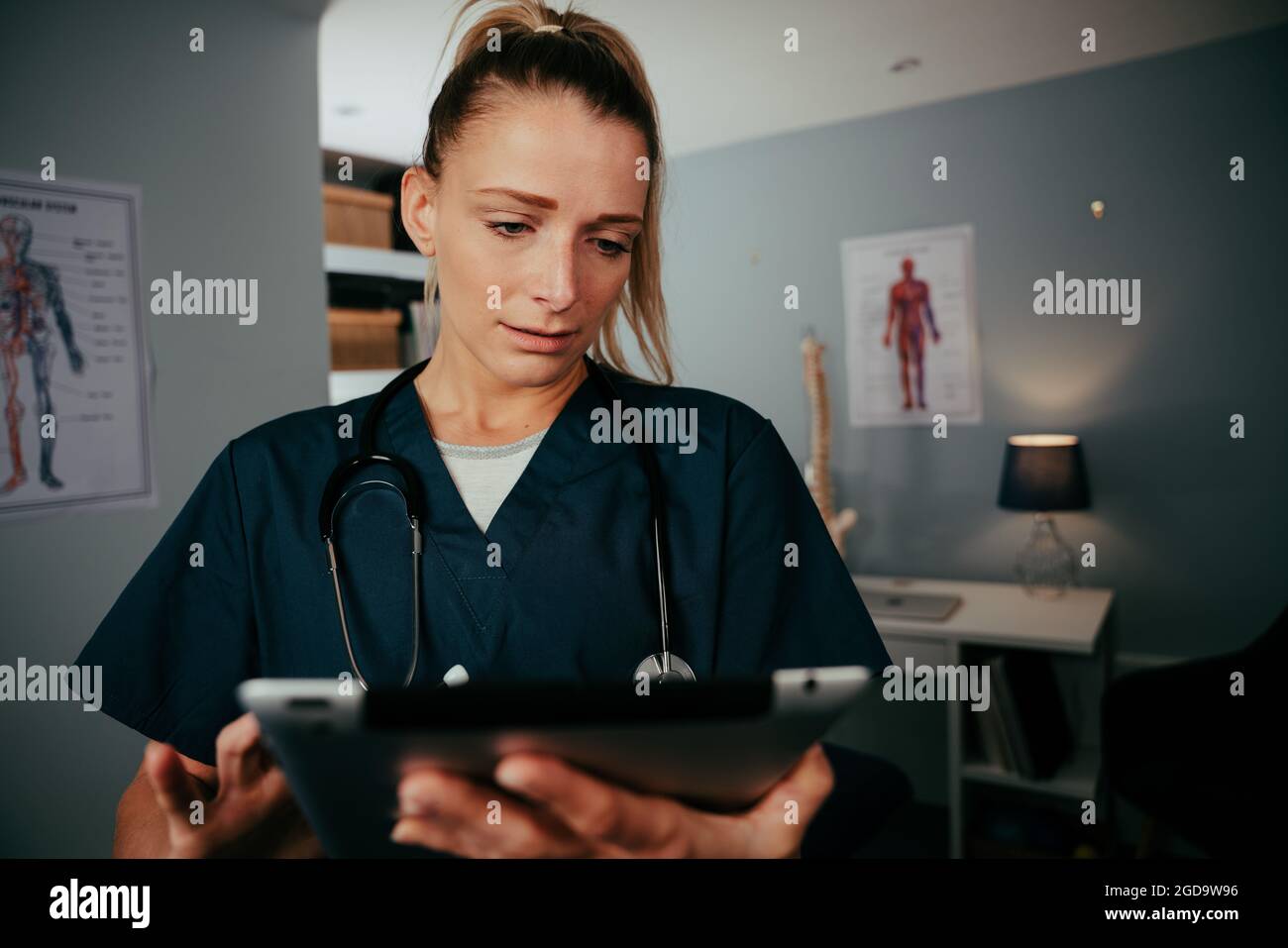 Caucasian female nurse researching on digital tablet  Stock Photo