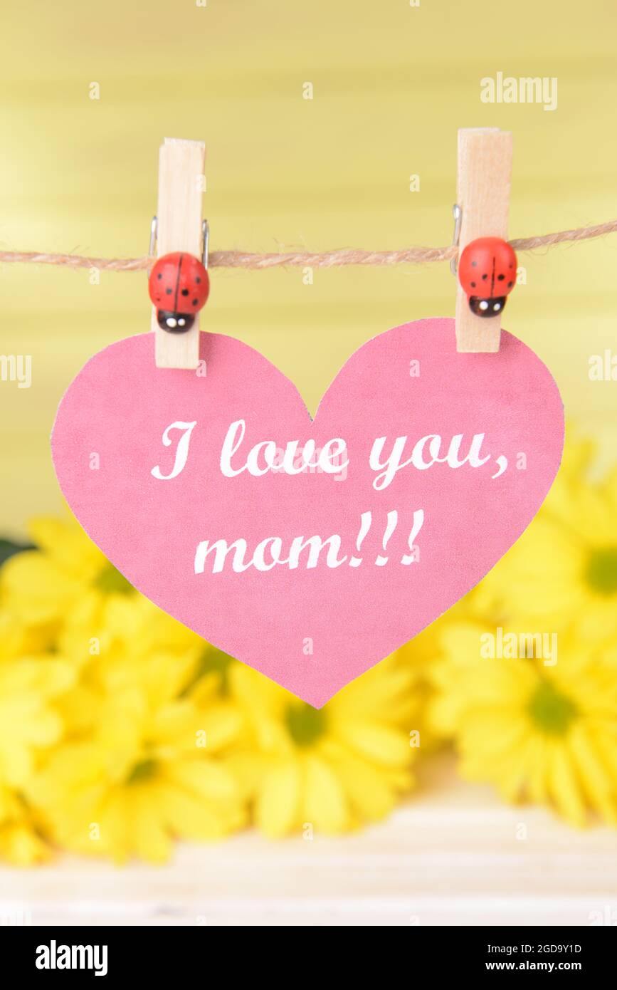 Happy Mothers Day Message Written On Paper Heart With Flowers On Yellow Background Stock Photo