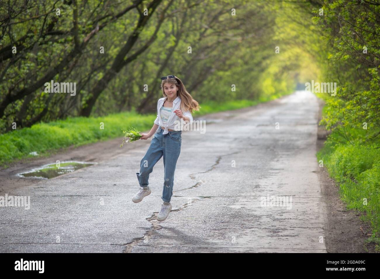 fashionable little girl standing walking on the road against the ...