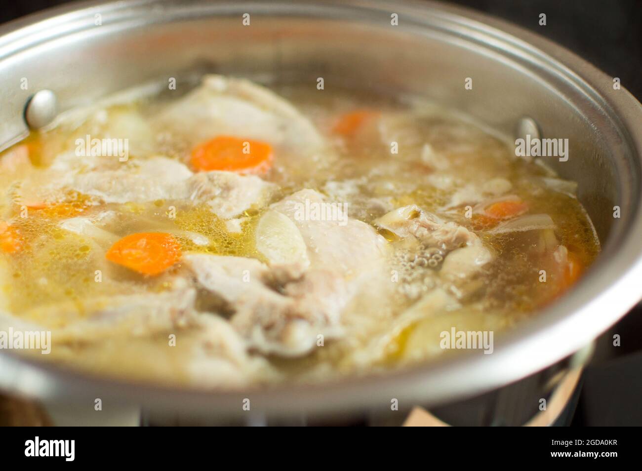 The broth is boiling in a saucepan. Meat and vegetables are boiled