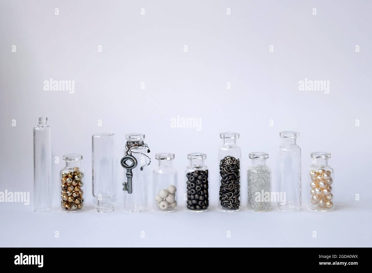 https://c8.alamy.com/comp/2GDA0WX/small-glass-jars-stand-side-by-side-in-one-line-transparent-containers-filled-with-beads-2GDA0WX.jpg