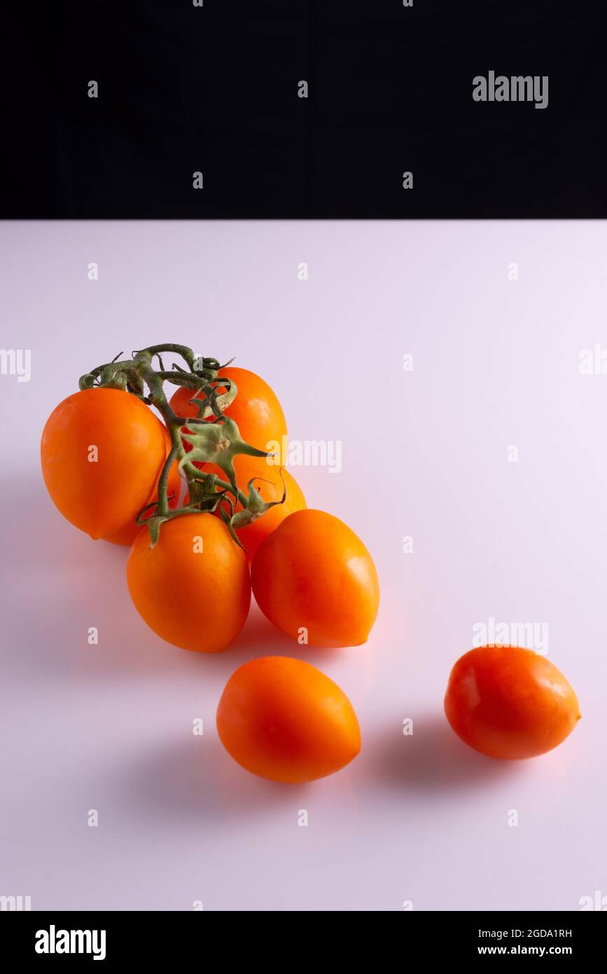 branch of fresh red tomatoes on black and white background Stock Photo ...