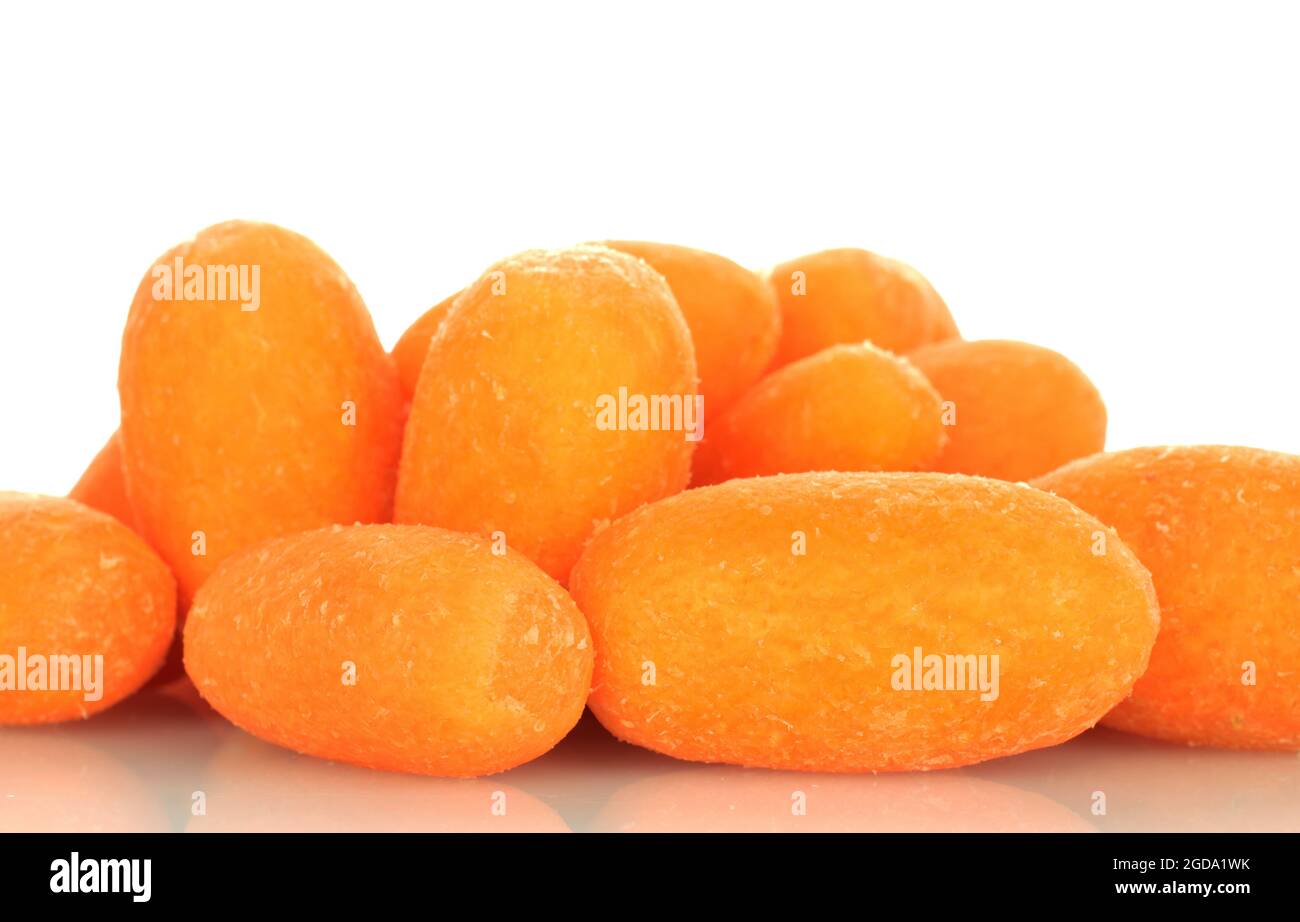 Several bright orange organic mini carrots, close-up, on a white background. Stock Photo