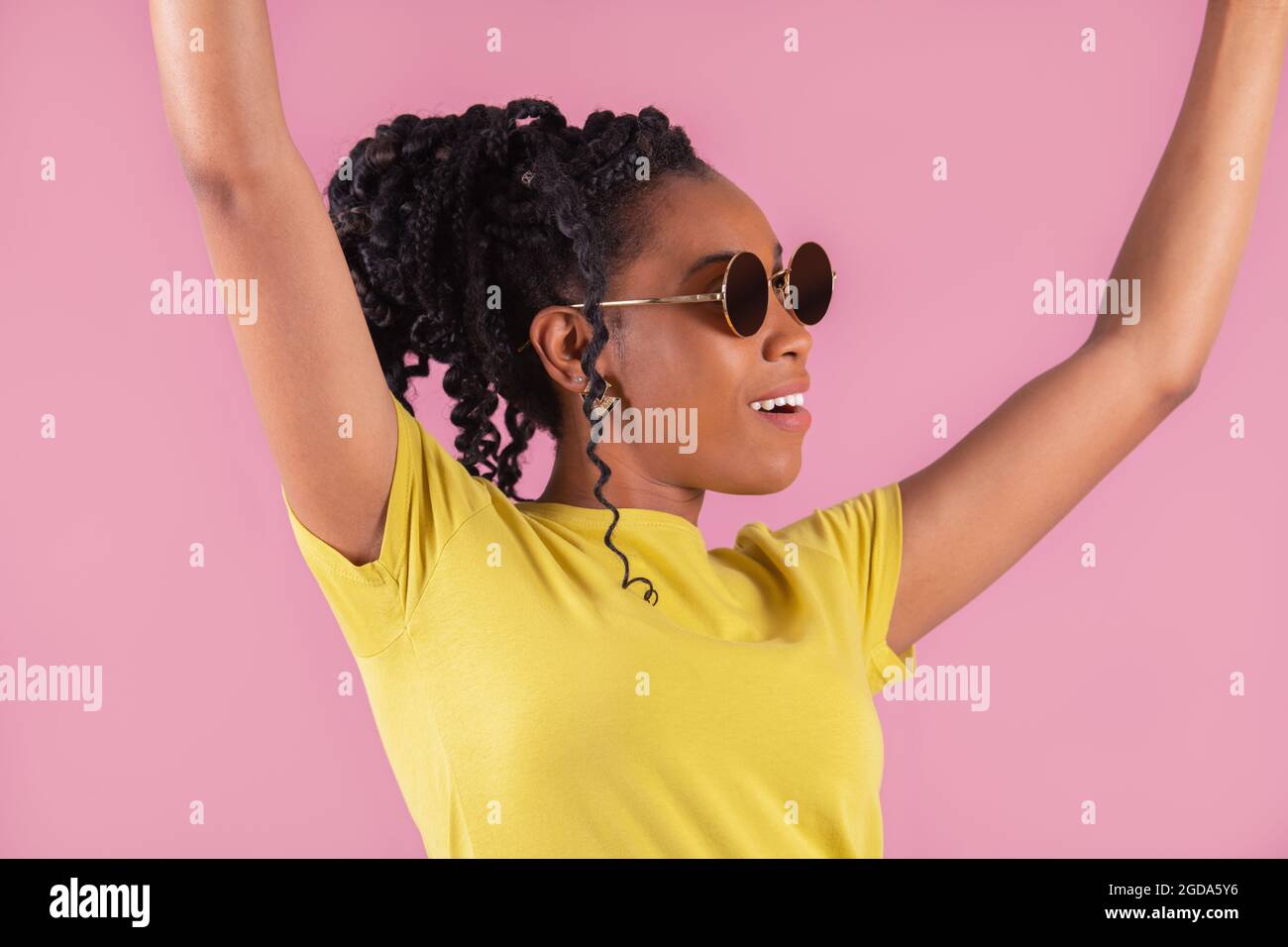 Smiling afro american woman raising her arms in celebration Stock Photo ...