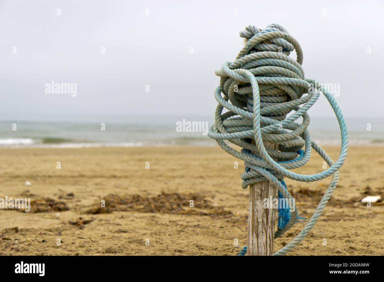 Bundle of rope on a post on a beach Stock Photo - Alamy
