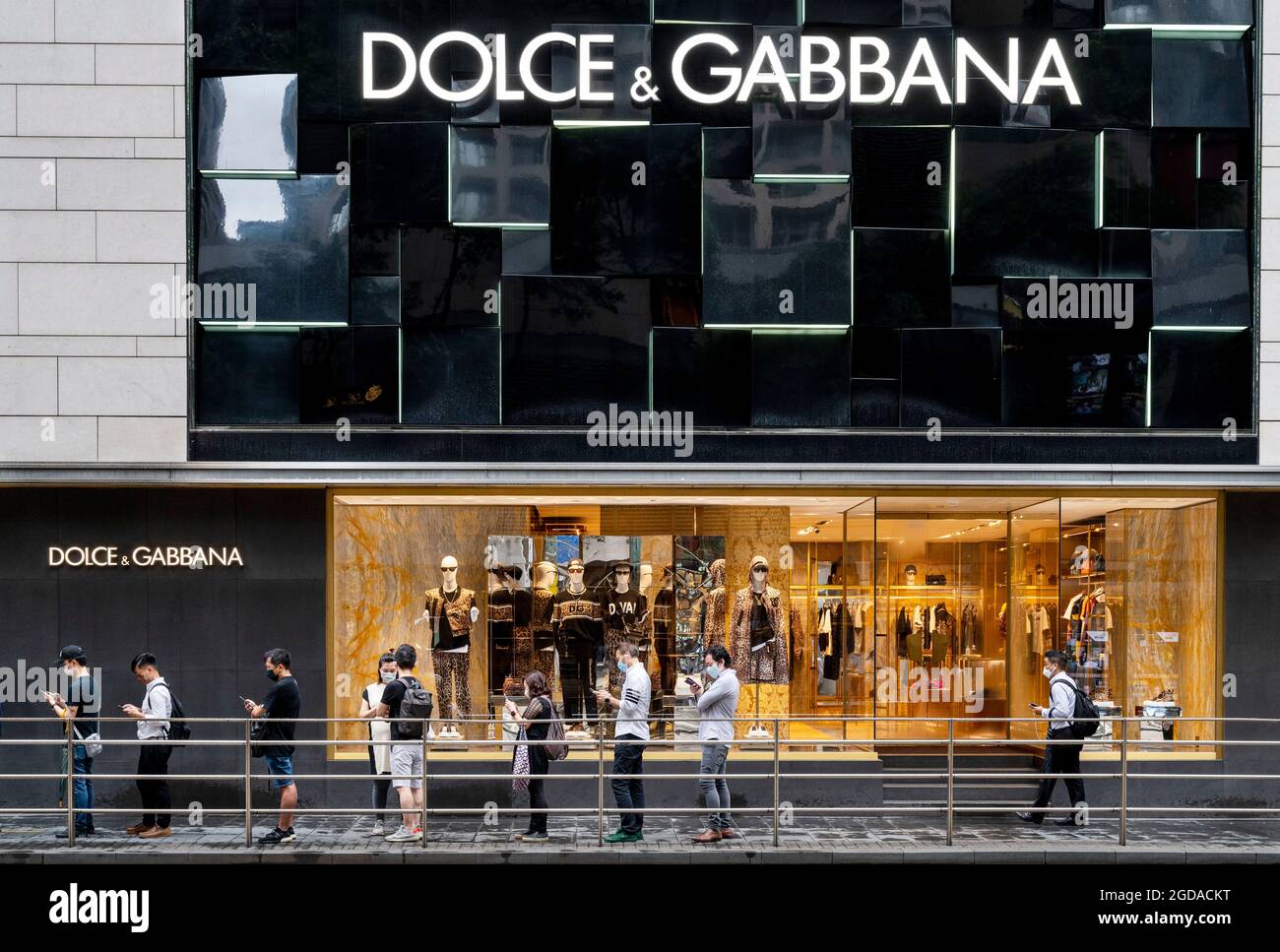Shoppers stand in front of the Italian luxury fashion house Dolce & Gabbana  store in Hong Kong Stock Photo - Alamy