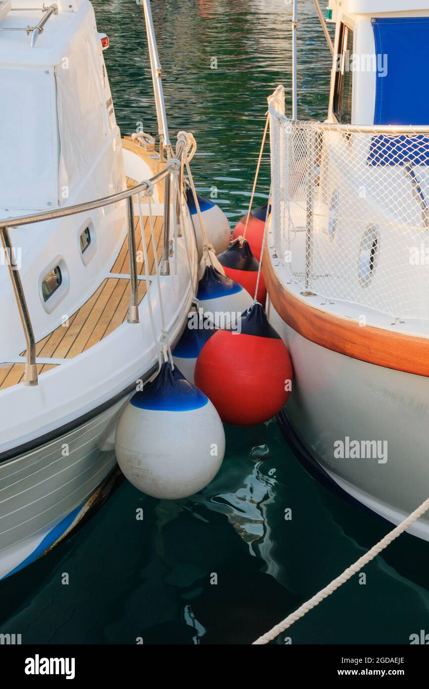 Buoys between yachts in sea coast in marina dock. Summer vacation. Stock Photo