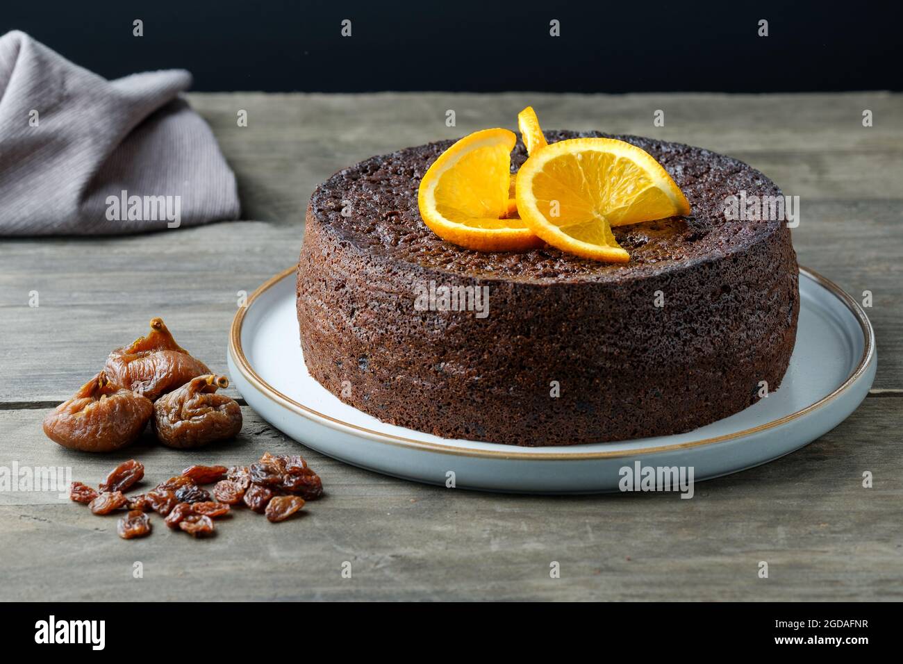 A home baked orange, chocolate, fruit cake made using a Nigella Lawson recipe. The moist cake is decorated with slices of fresh orange Stock Photo