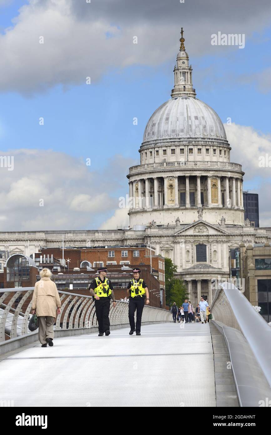 London, England, UK. Police officer on the Millennium Bridge, looking towards St Paul's Cathedral Stock Photo