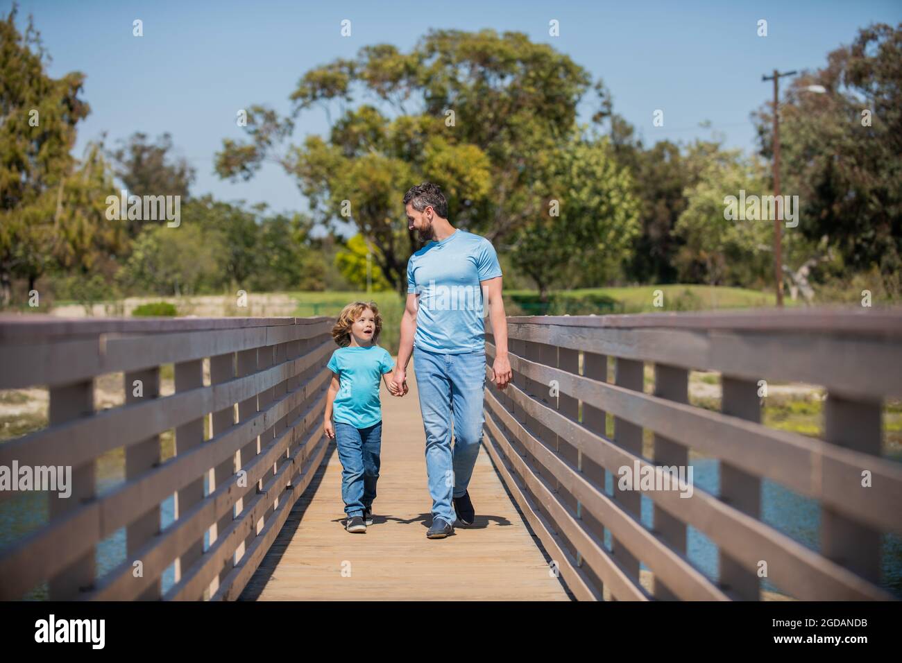 smiling single father leading small kid outside, parenting Stock Photo
