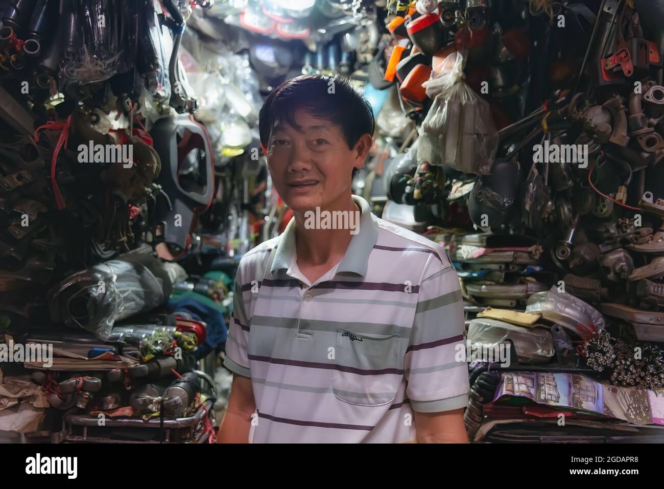 Phnom Penh, Cambodia - December 31, 2016: A spare parts vendor looking at camera in his shop at the Russian market Stock Photo