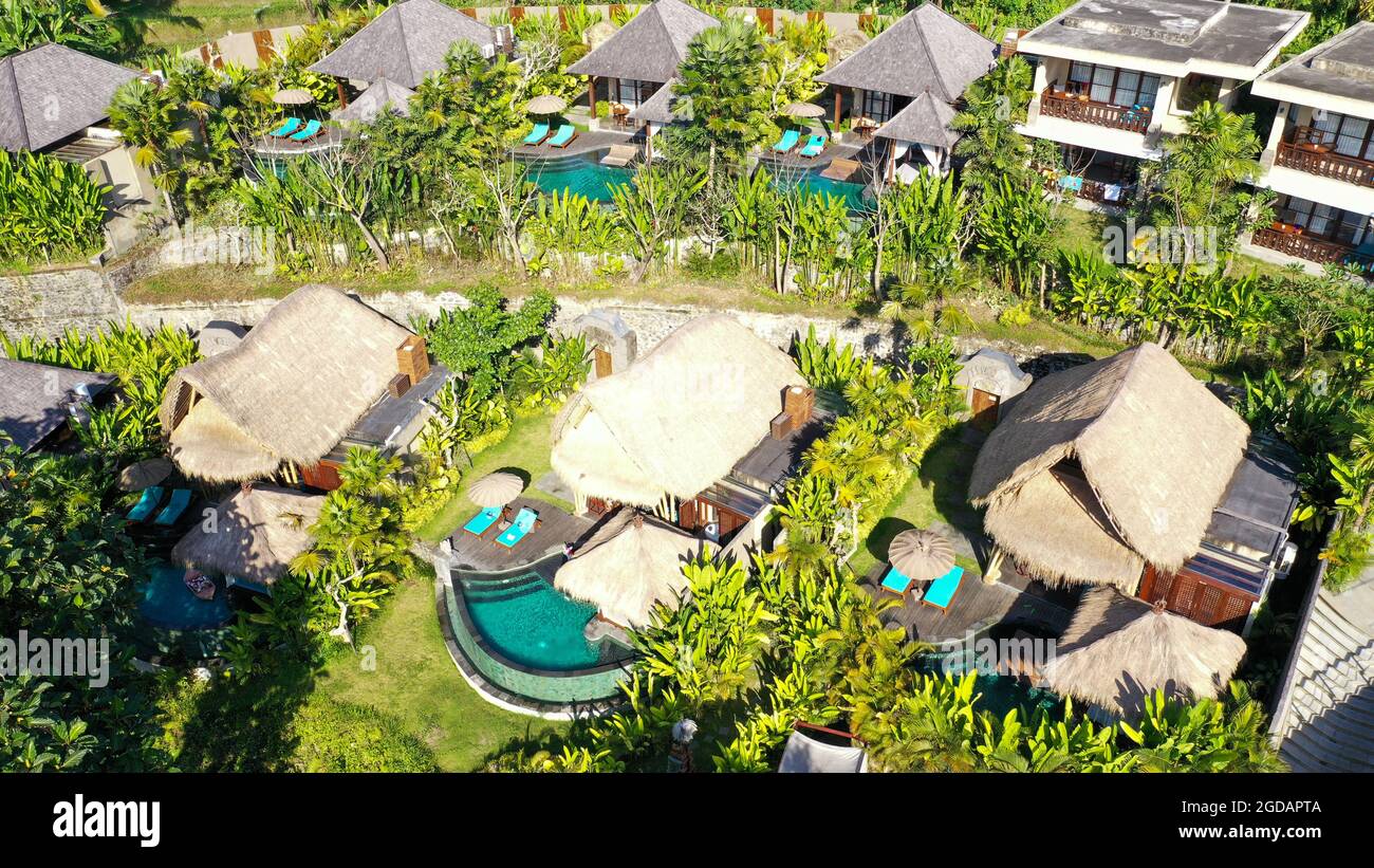 Aerial view of luxury hotel with straw roof villas and pools in ...