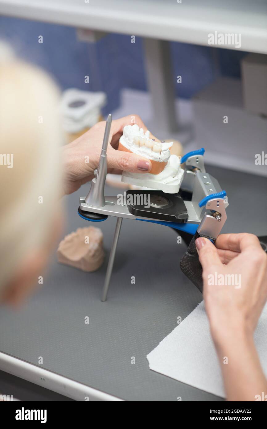 Dental prosthesis. Prosthetist working with equipment at the dental clinic Stock Photo Alamy