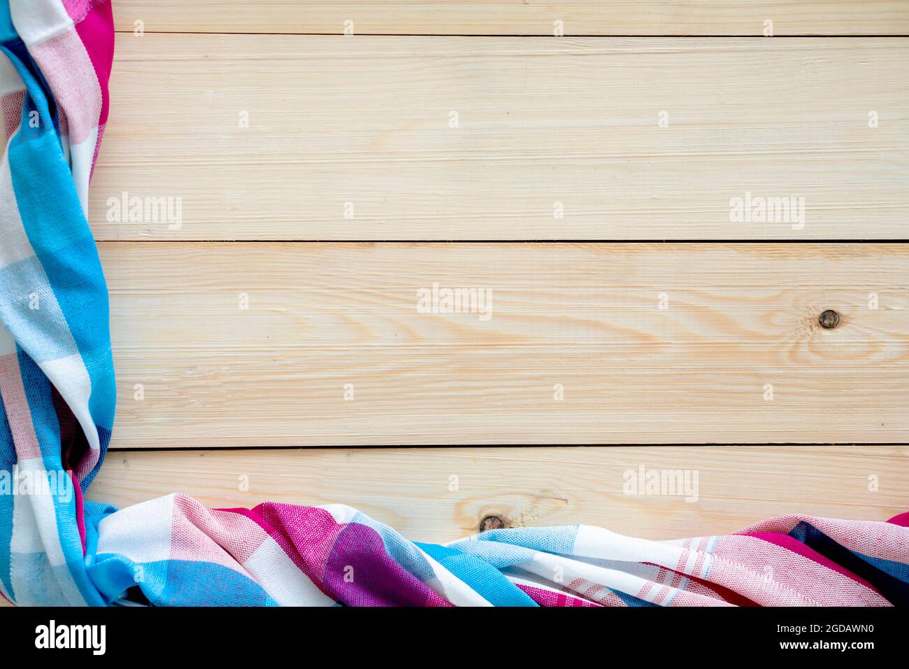 Checkered fabric on wood table background. Stock Photo