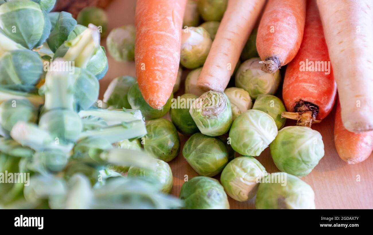 Various vegetables including brussel spouts, carrots and parsnips being prepared for Christmas lunch. Stock Photo