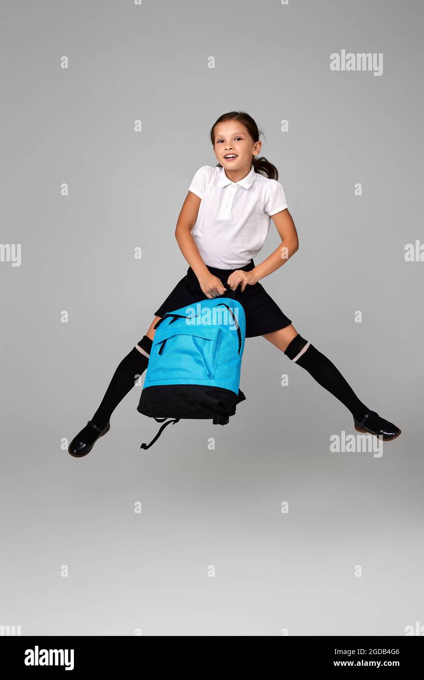 cute happy schoolgirl jumping up with backpack Stock Photo
