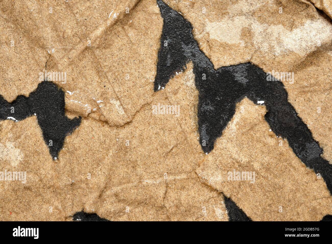 Wet Torn Brown Paper on Black background. Stock Photo
