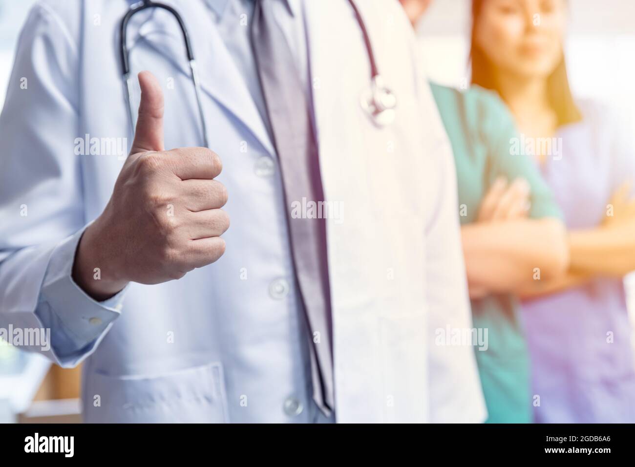 Doctor medical team with hand thumbs up positive sign for good care confirm virus protected service healthcare concept. Stock Photo