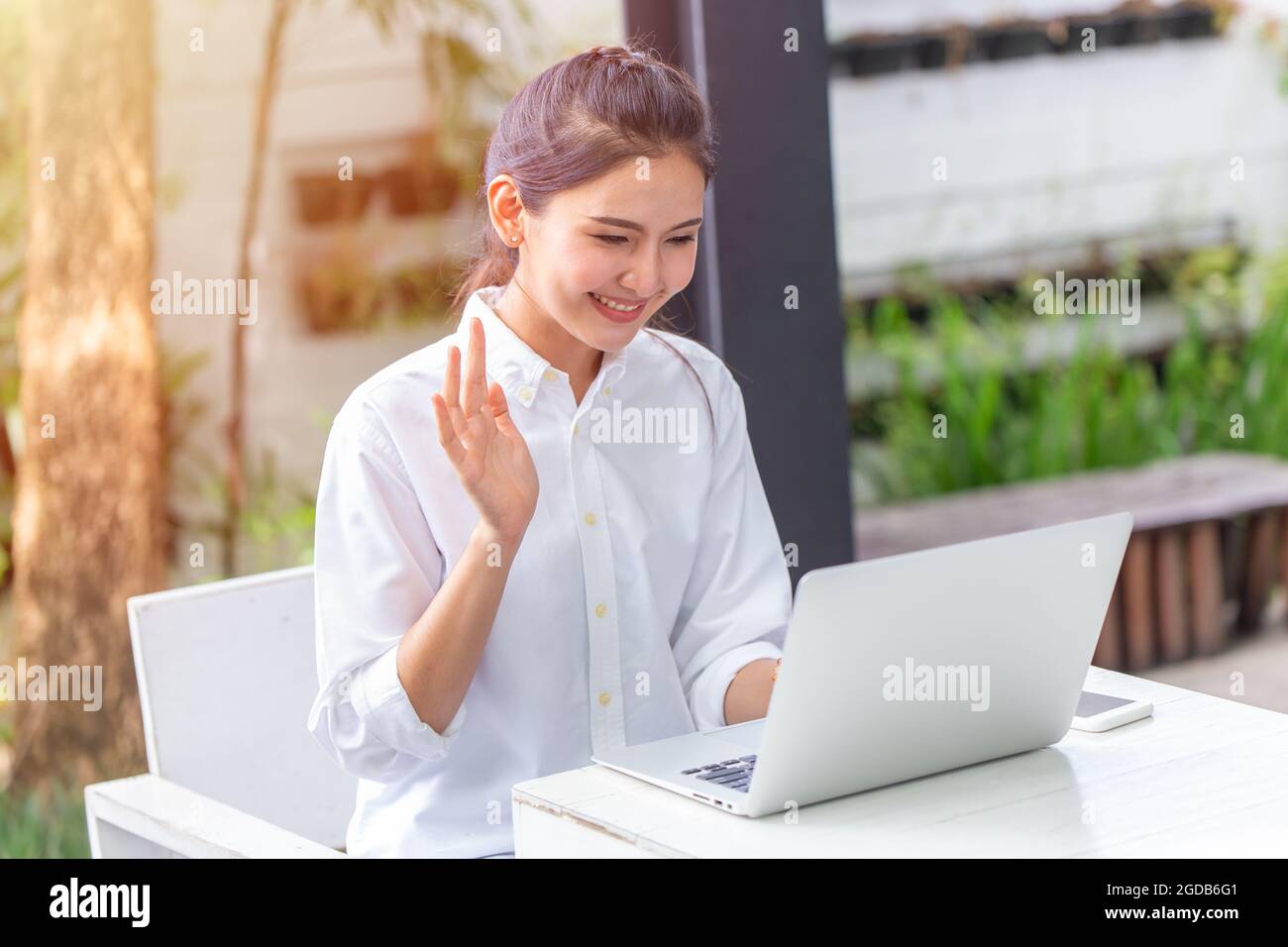 Asian Women happy work at home with laptop computer hand greeting to online people video call. Stock Photo