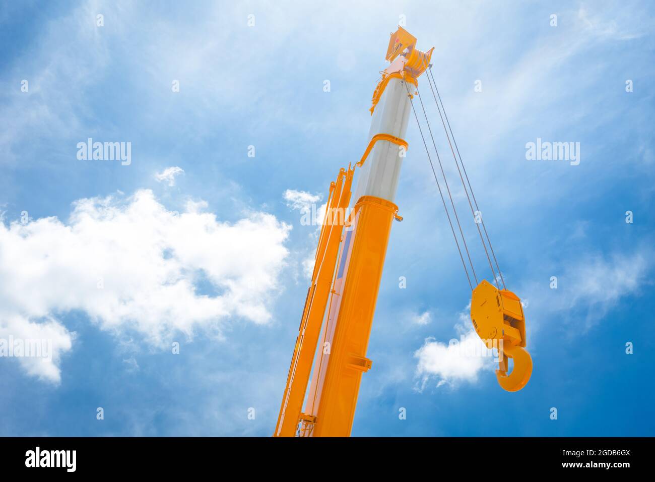 Hoist crane yellow hook head construction truck clean new with blue sky cloud background. Stock Photo