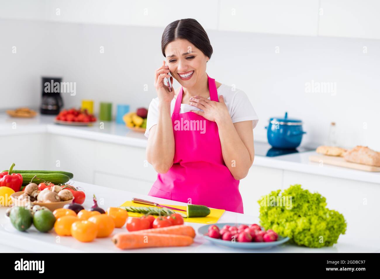 Woman in hair curlers taking funny selfie on mobile while cooking in the  kitchen Stock Photo - Alamy
