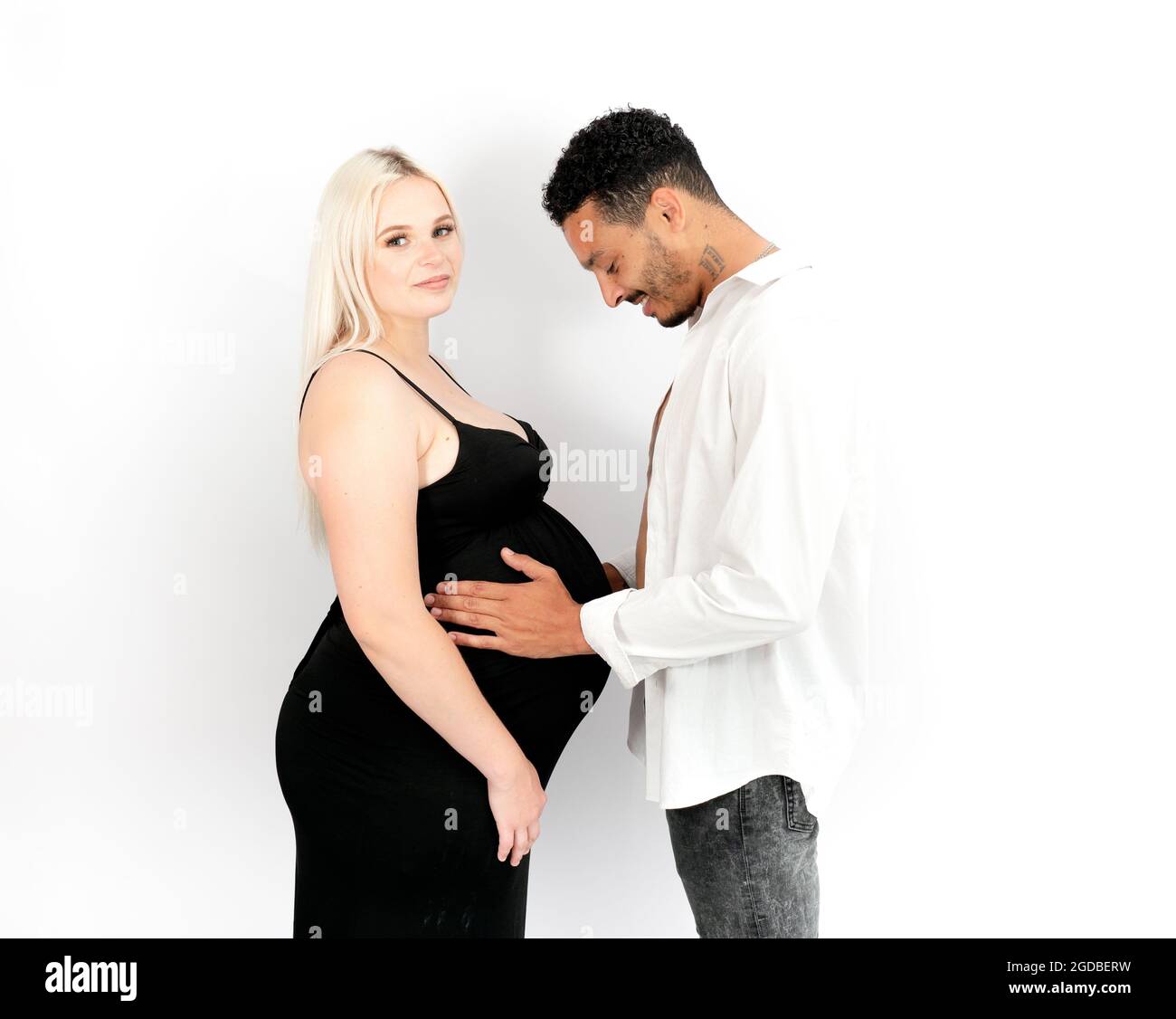 Profile view of a stylish and happy multi-ethnic couple expecting a baby Stock Photo