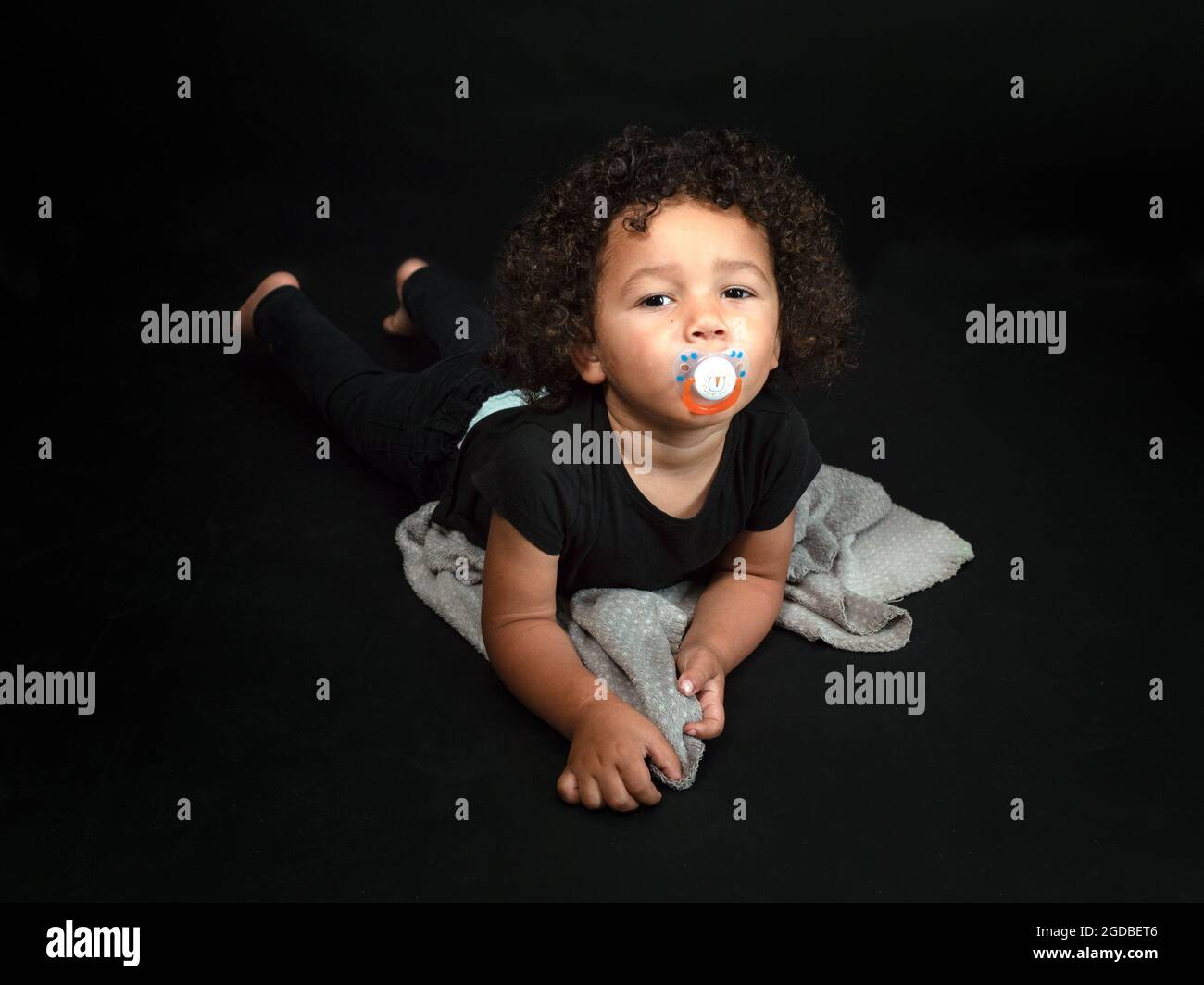 Horizontal portrait of a beautiful mixed race 2 years and half old boy sucking a nipple Stock Photo