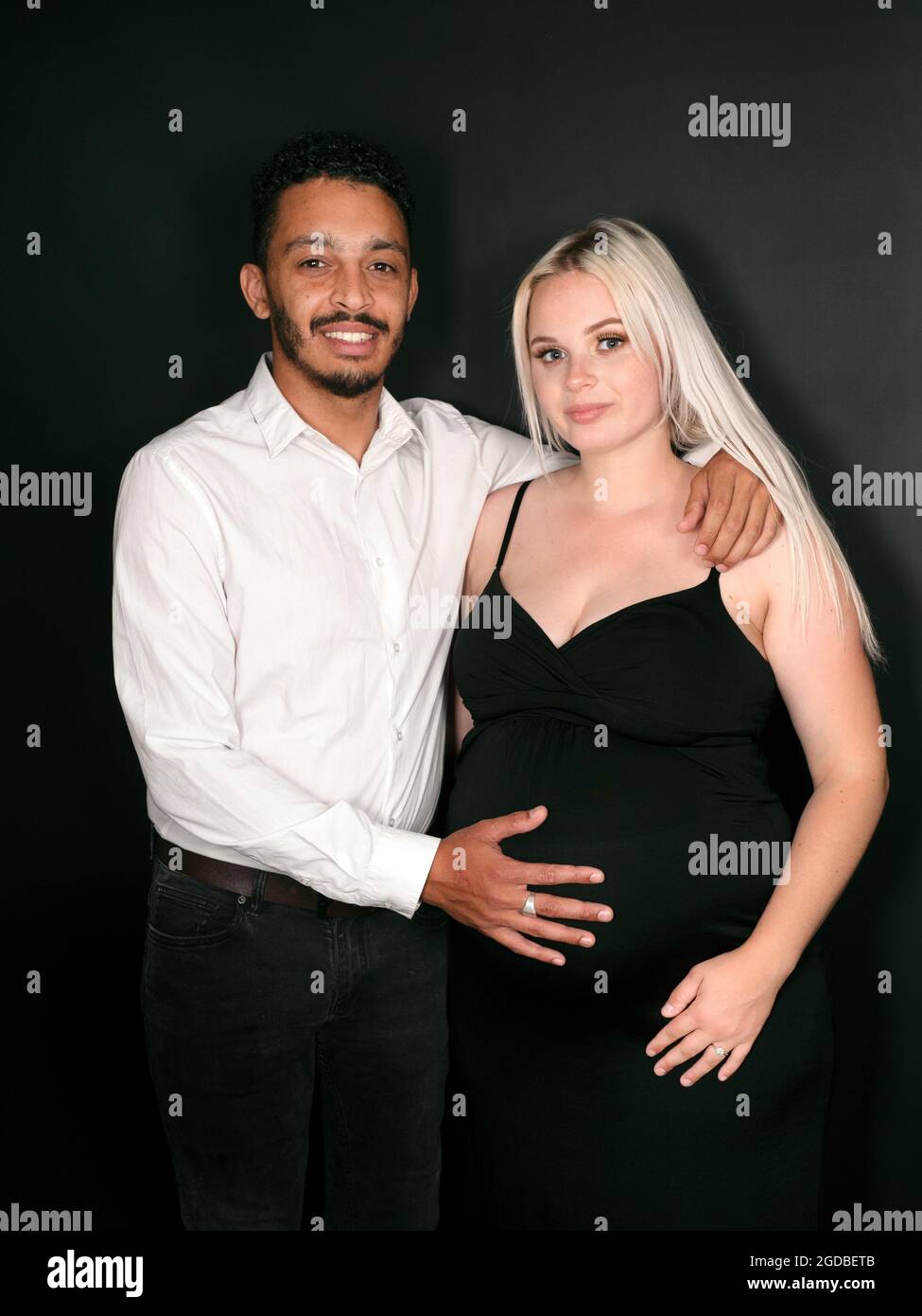 Mixed race fathertobe holding his caucasian pregnant wife's belly