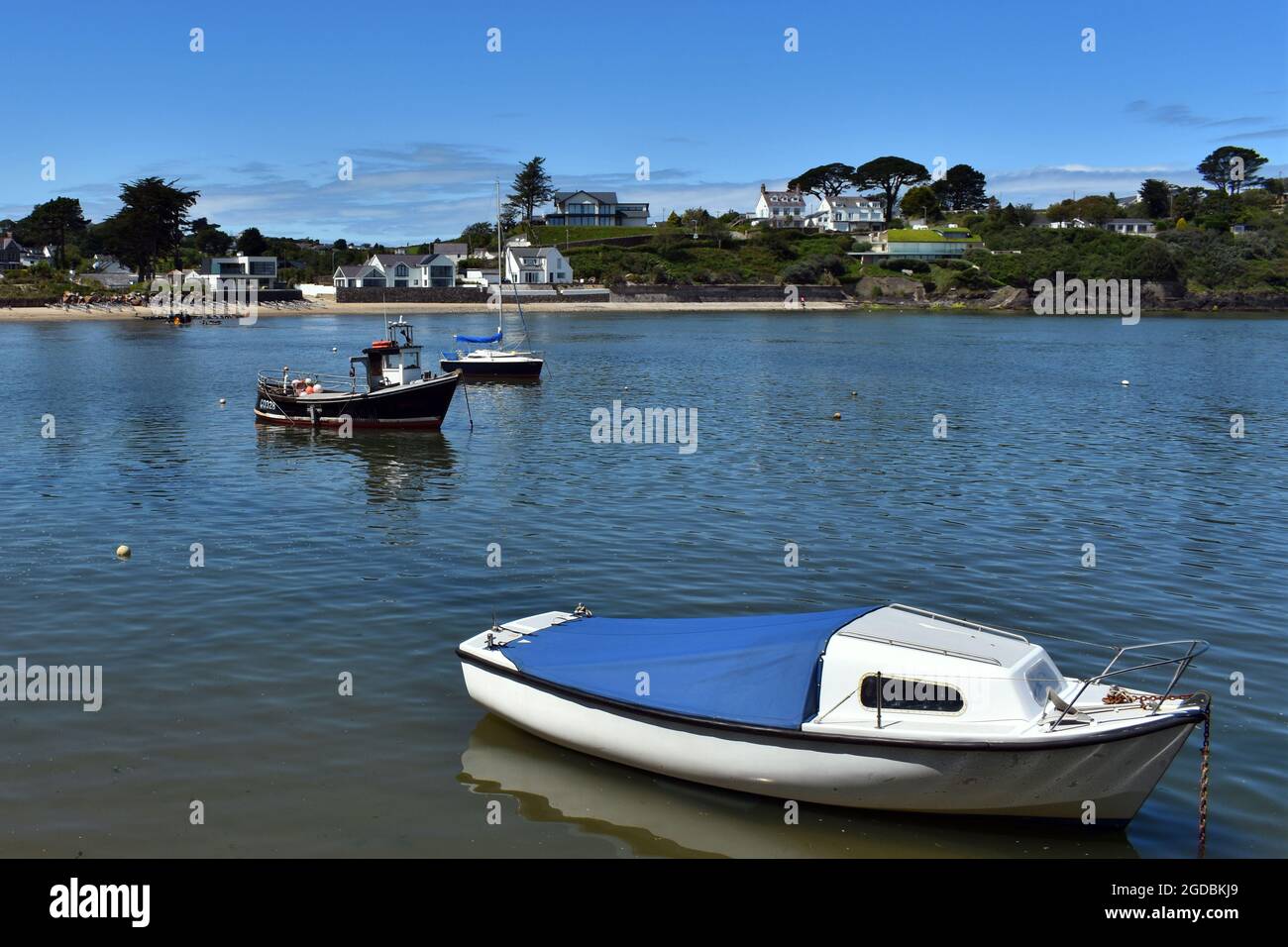 Two small boats in a quiet bay at the delightful seaside resort of Abersoch,  Wales.  A sunny summers day with blue skies.  Copy space. Stock Photo